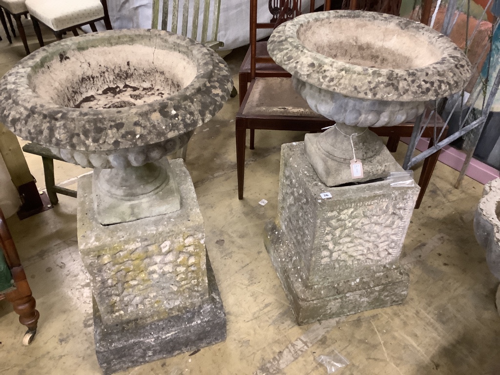 A pair of reconstituted stone urns on plinths, diameter 58cm, height 94cm